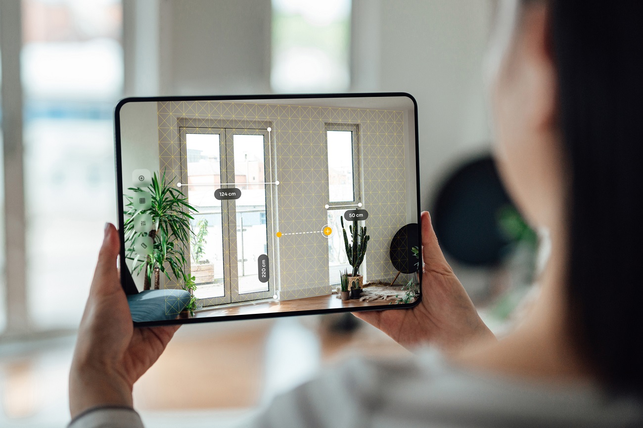Person taking a picture on an iPad using AI for virtual home staging and design | © Oscar Wong / Moment / Getty Images