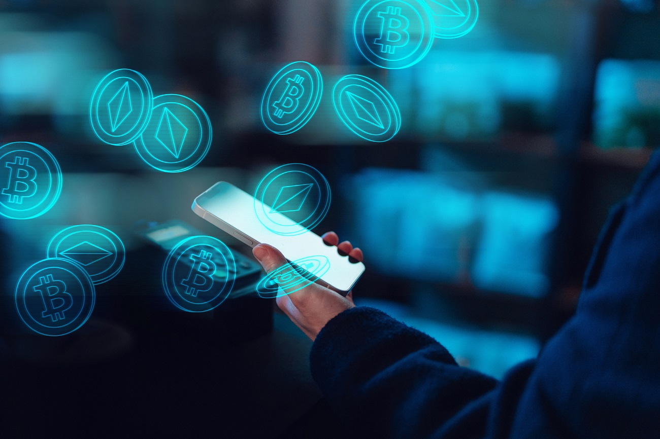 Person using a mobile app on a smartphone to pay with digital currency | © Oscar Wong / Moment / Getty Images